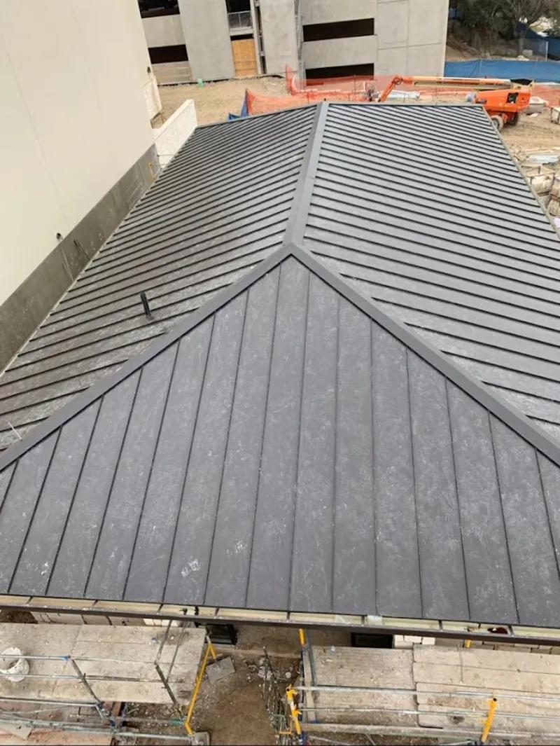 Commercial metal roof construction with crane equipment in Moyock